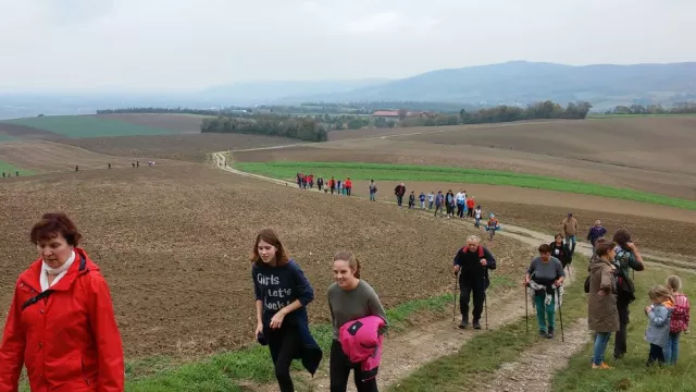 Foto Menschengruppe wandert über Feldweg bergauf